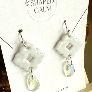 White dangle earrings with clear teardrop