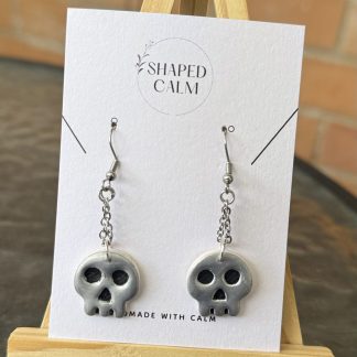 Silver skull on chain dangle earrings